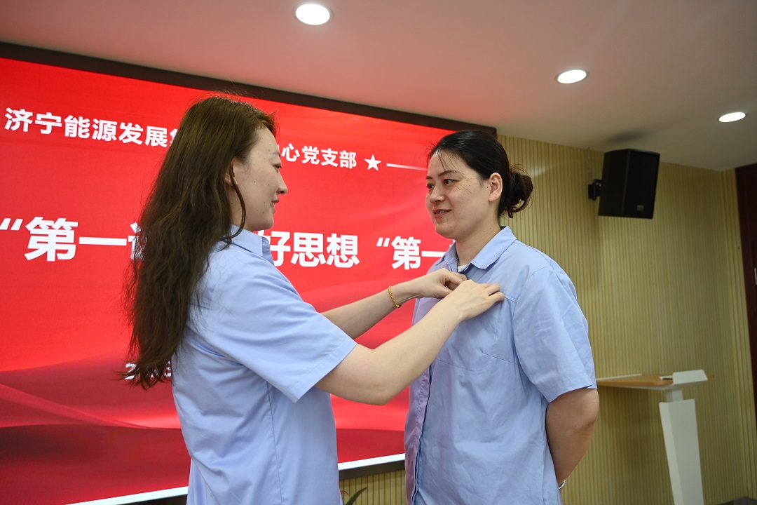 1697529443417408.jpg 2023年7月7日,老党员张旭为新党员戴党徽(地点:正则招标1112室,拍摄人:靳溢欣) - 网站.JPG